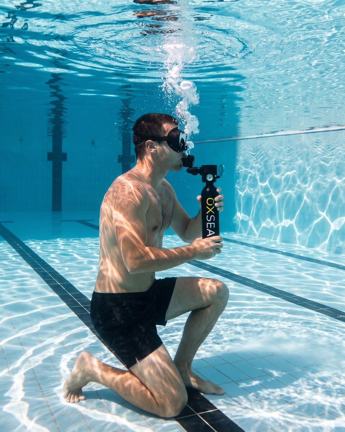 Premiers essais en piscine, à genoux au fond du bassin